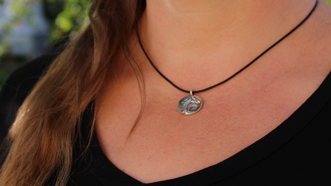 Silver horse pendant with natural rough sapphire