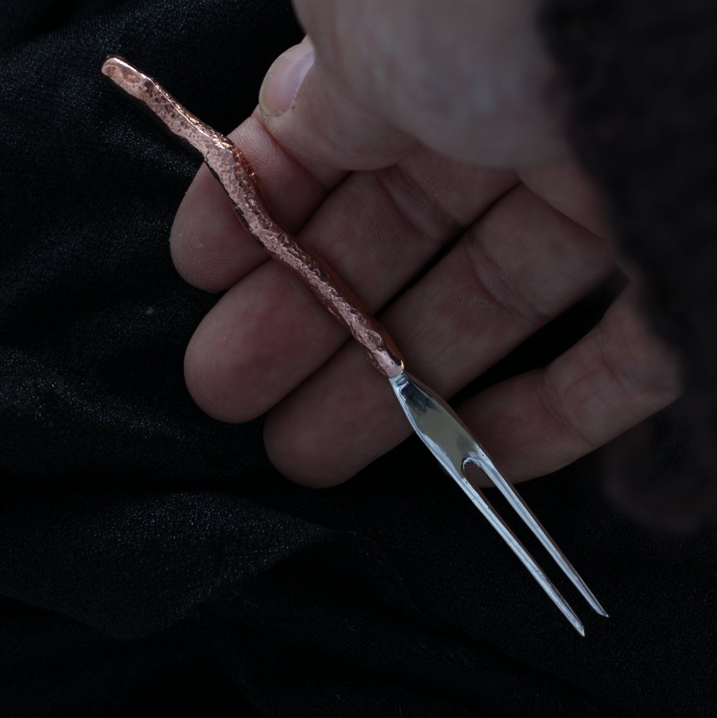 holding sterling silver gnomes cocktail fork in hand