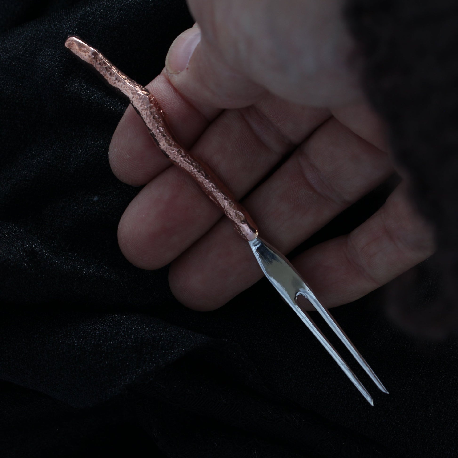 holding sterling silver gnomes cocktail fork in hand