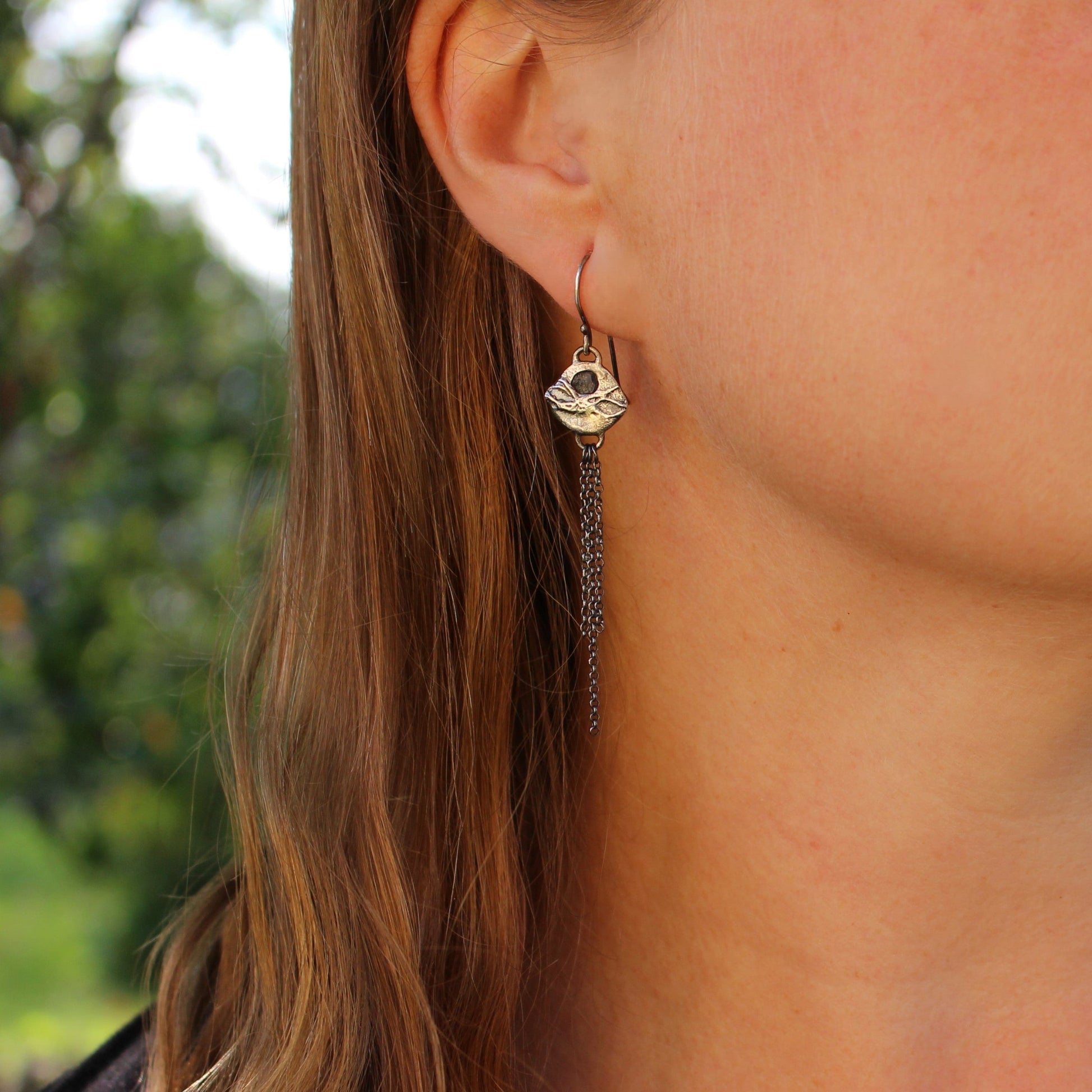 silver drop earrings on ear