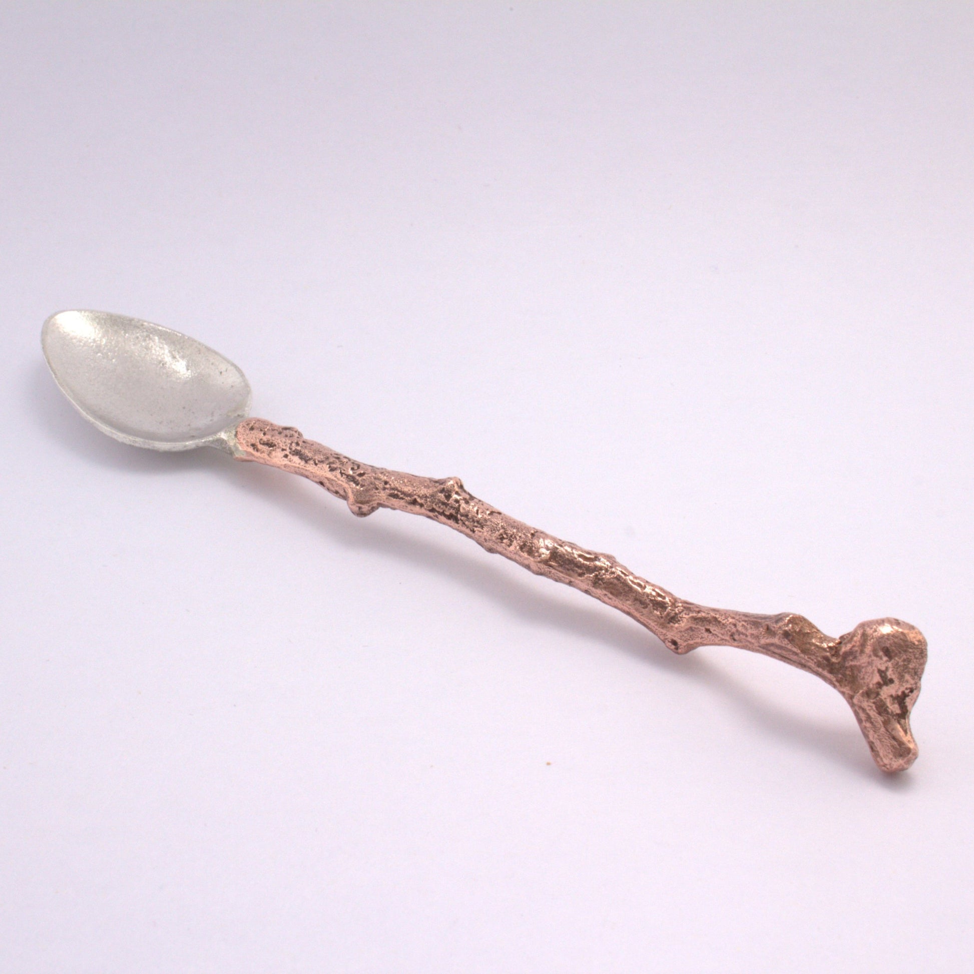 silver spoon with stick copper handle